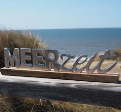 Schriftzug Meerzeit auf Holzfuß